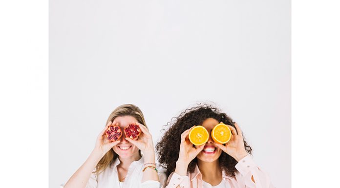 Two happy women having fruits for stress relief